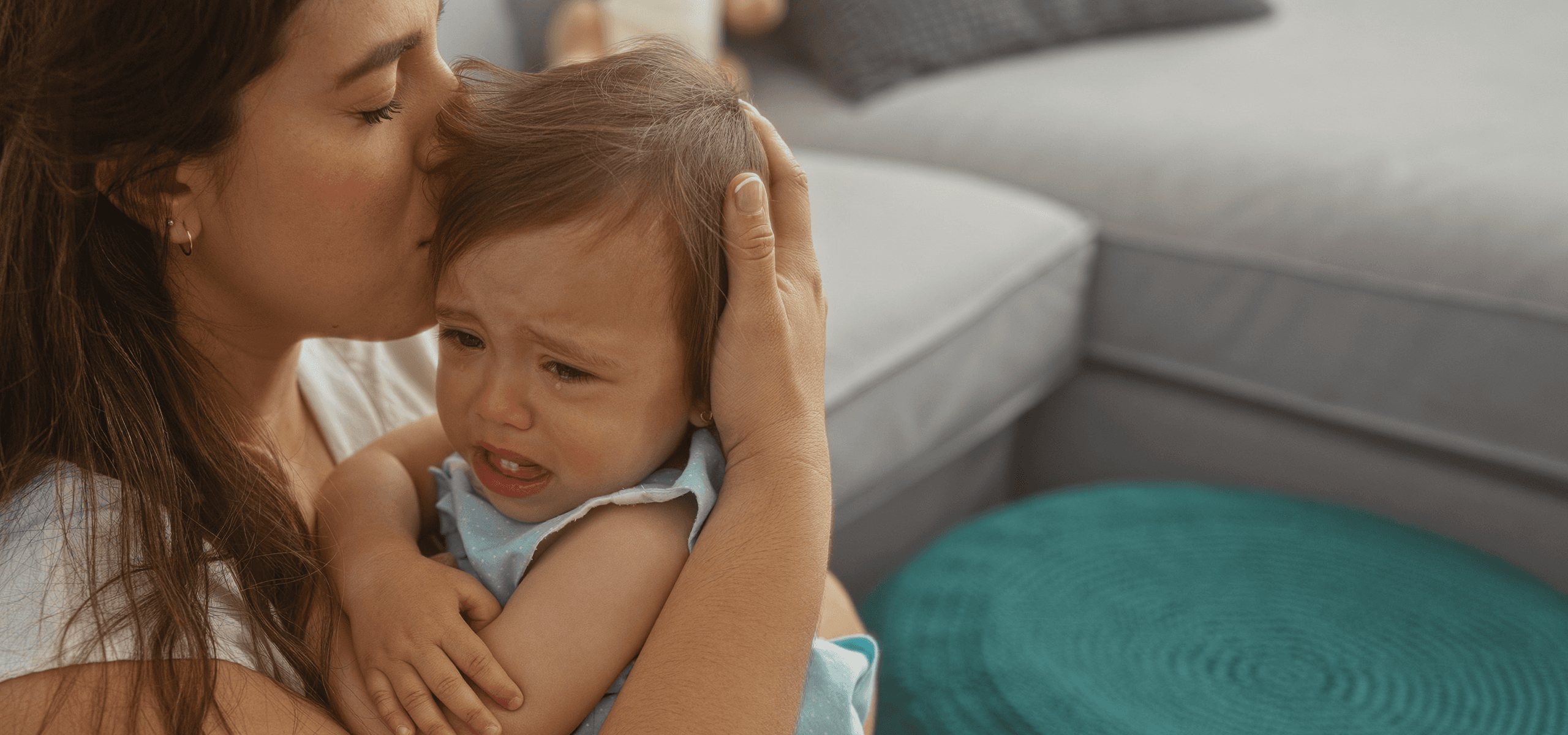 A mother holding and comforting her crying toddler